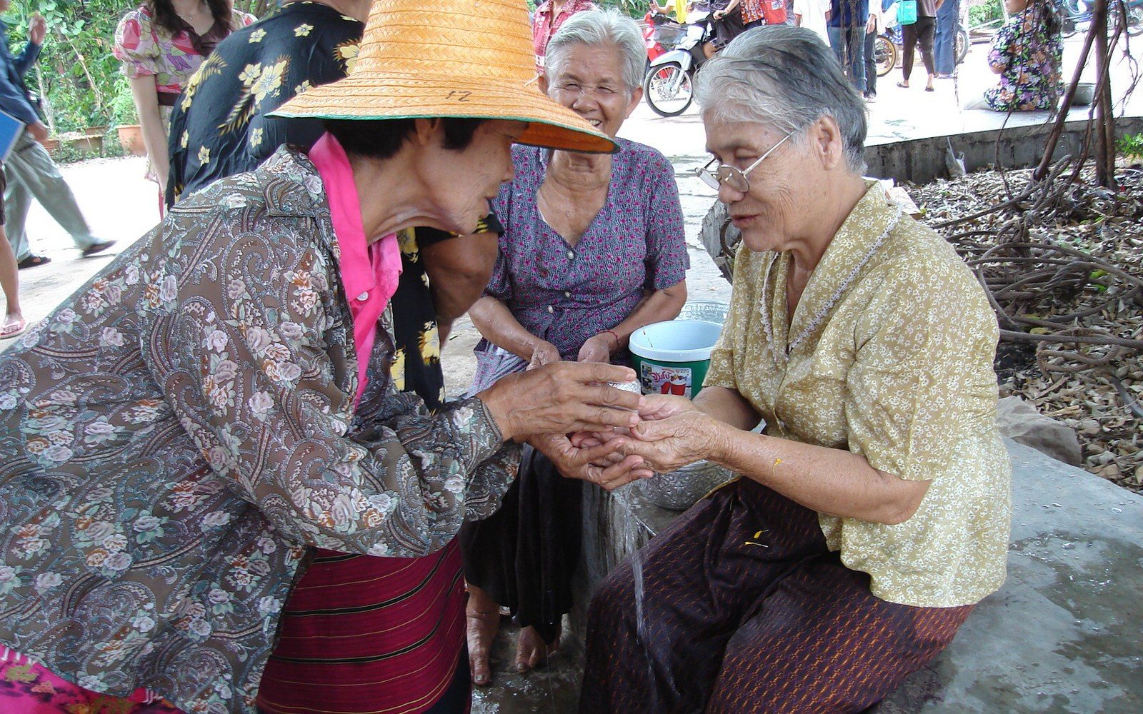 Water poured from a silver bowl over an older person's hands